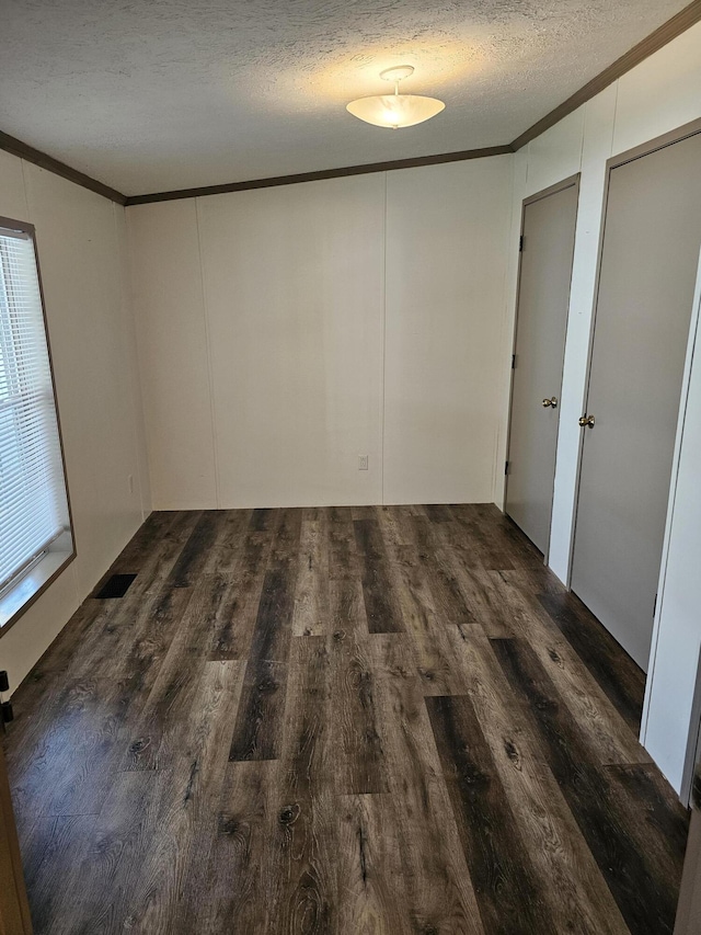 11524 Powhattan Path, Lakeview, OH 43331 - spare room with crown molding, a textured ceiling, dark wood-style flooring, and a decorative wall
