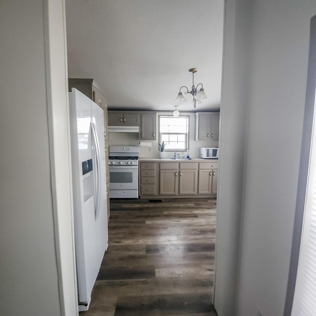 11524 Powhattan Path, Lakeview, OH 43331 - kitchen featuring white appliances, a sink, a chandelier, under cabinet range hood, and dark wood finished floors