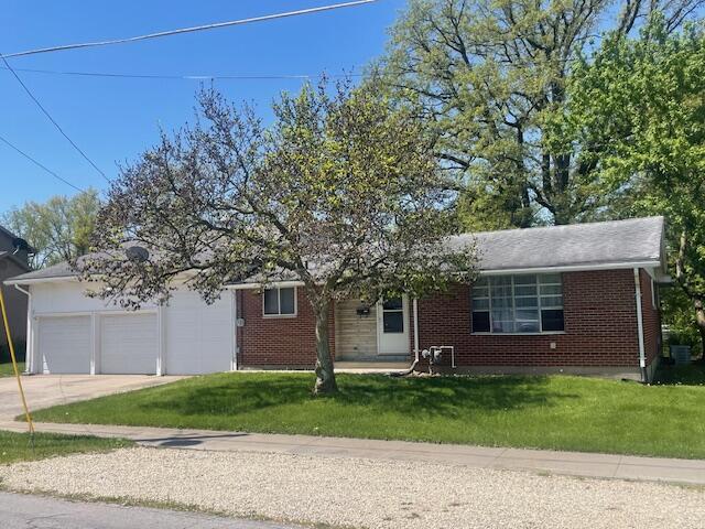 209 N Kenilworth Ave, Lima, OH 45805 - view of front of house featuring concrete driveway, a garage, a front lawn, and brick siding