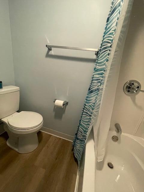 209 N Kenilworth Ave, Lima, OH 45805 - full bathroom with wood finished floors, toilet, shower / bath combo with shower curtain, and baseboards
