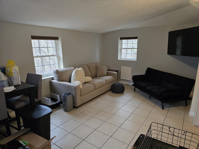 living area featuring light tile patterned floors, a textured ceiling, and a healthy amount of sunlight