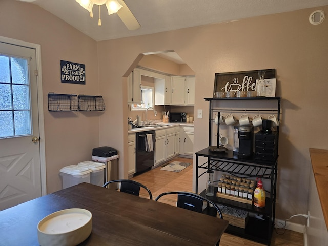 dining area with light wood finished floors, baseboards, ceiling fan, lofted ceiling, and arched walkways