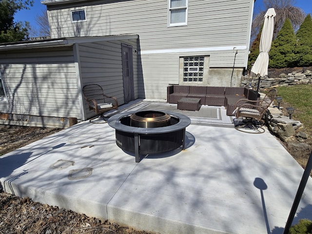 view of patio with an outdoor living space with a fire pit