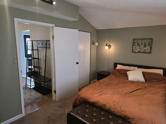 bedroom with lofted ceiling, baseboards, and carpet floors