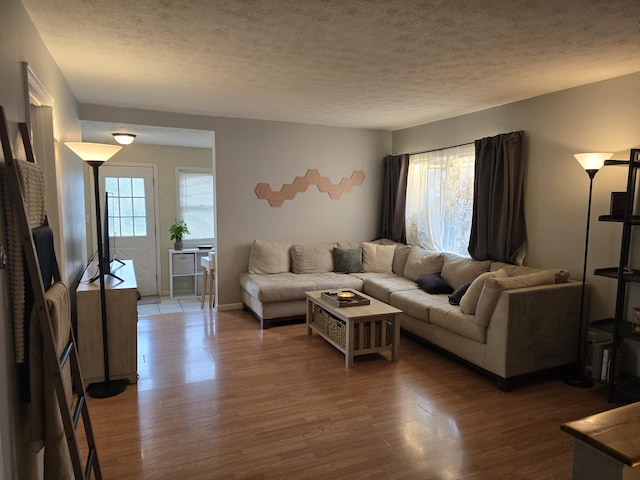 living room featuring a textured ceiling, a healthy amount of sunlight, and wood finished floors