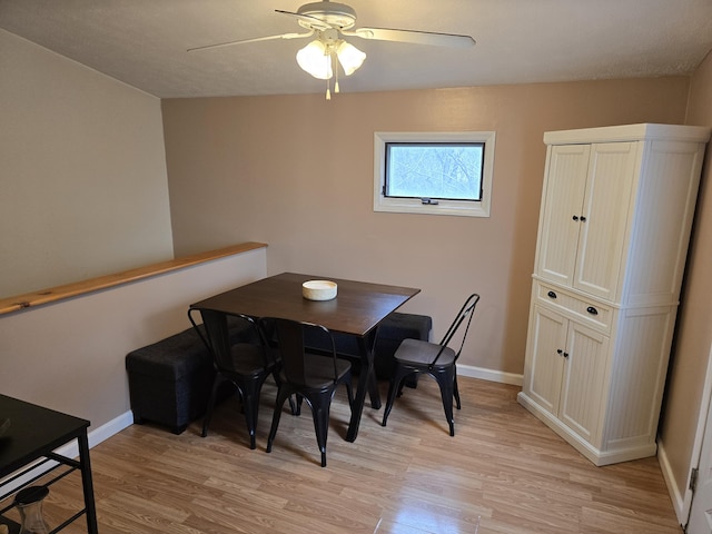 dining space with light wood-type flooring, baseboards, and a ceiling fan