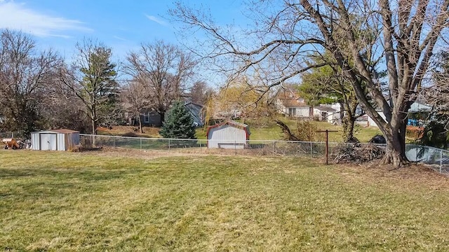 view of yard with a storage unit, an outbuilding, and a fenced backyard