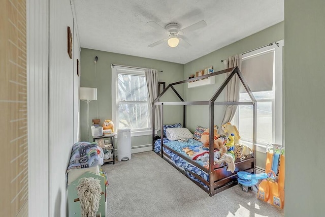 carpeted bedroom with a ceiling fan and baseboard heating