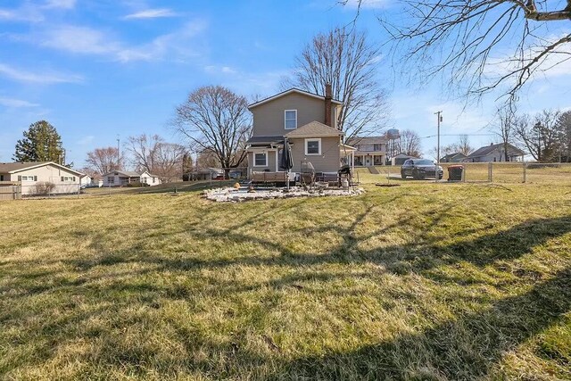 back of house with a residential view, a lawn, and fence