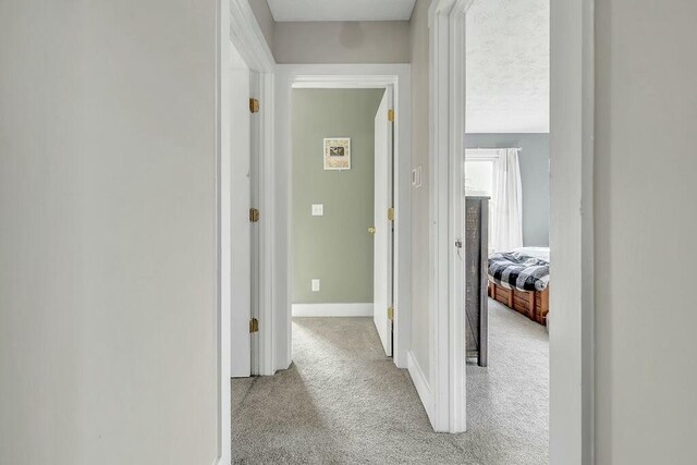 hall with carpet flooring and baseboards