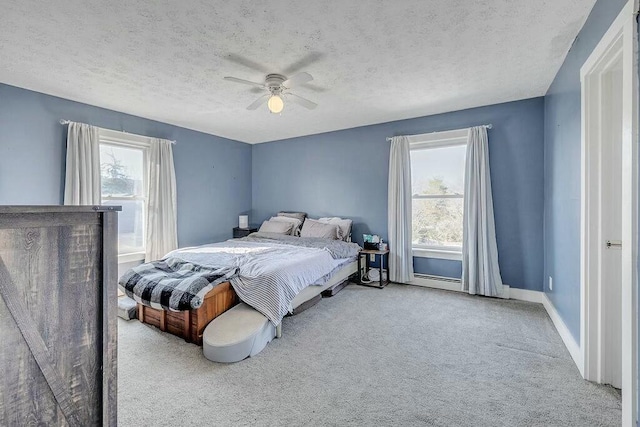 bedroom with multiple windows, a textured ceiling, carpet, and a ceiling fan