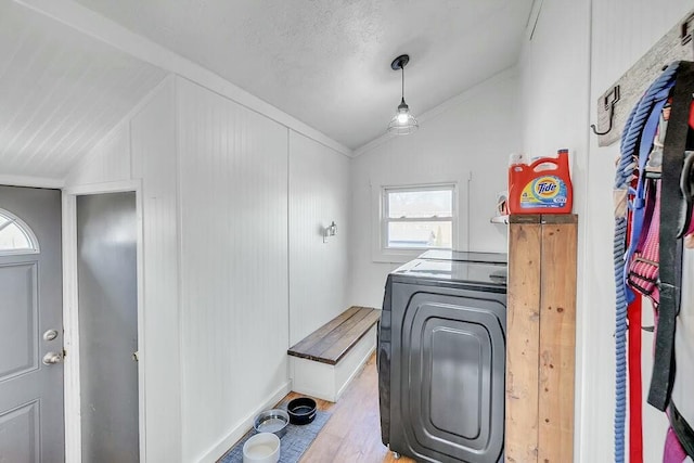 clothes washing area with laundry area, wood finished floors, and washer and clothes dryer