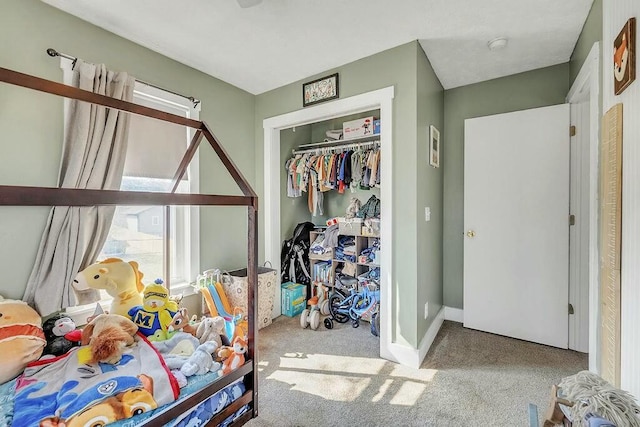 carpeted bedroom featuring baseboards and a closet