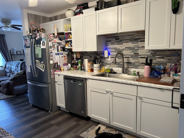 kitchen featuring light countertops, a sink, appliances with stainless steel finishes, ceiling fan, and dark wood-type flooring