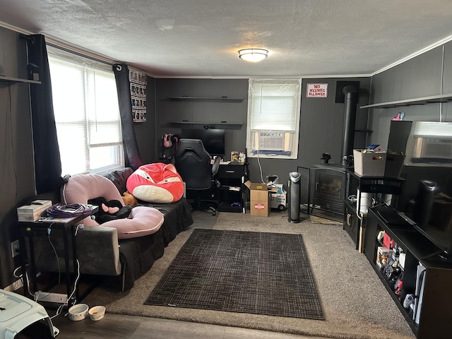 interior space featuring a textured ceiling, crown molding, carpet floors, cooling unit, and a wood stove