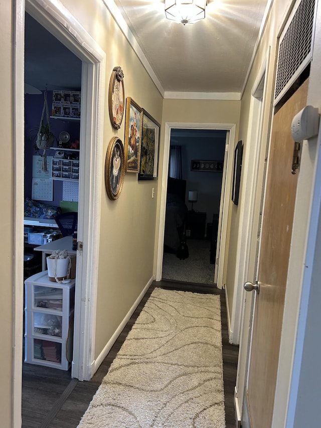 hallway featuring baseboards, dark wood-style flooring, and crown molding