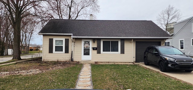 view of front facade featuring a front lawn, roof with shingles, an attached garage, and concrete driveway