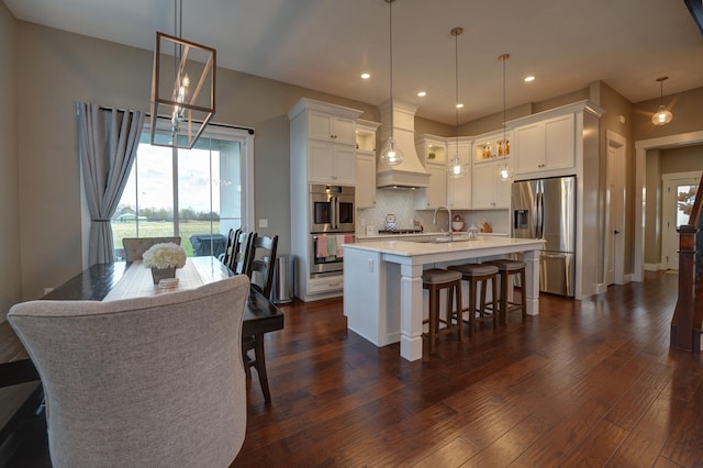 2737 Executive Dr, Troy, OH 45373 - kitchen featuring stainless steel appliances, premium range hood, white cabinetry, tasteful backsplash, and light countertops