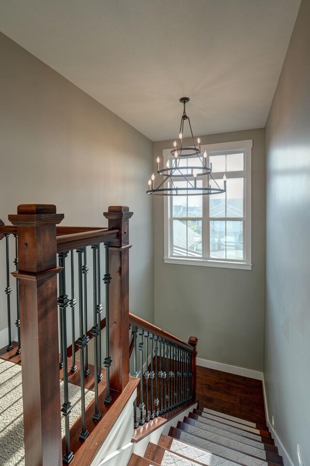 2737 Executive Dr, Troy, OH 45373 - stairs featuring baseboards, a chandelier, and wood finished floors