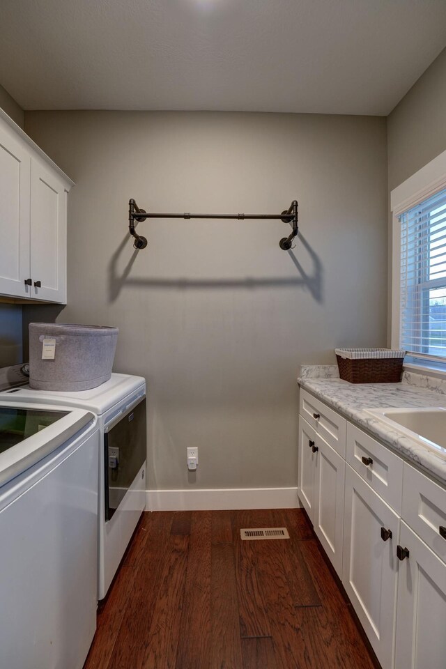 2737 Executive Dr, Troy, OH 45373 - laundry room featuring cabinet space, washing machine and dryer, dark wood-style flooring, and baseboards