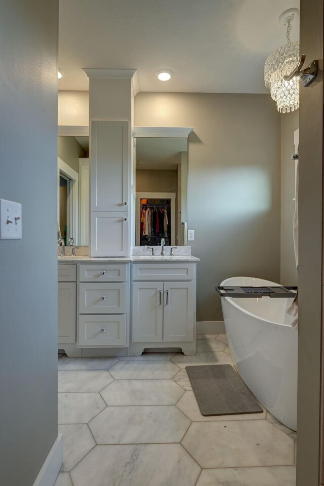 2737 Executive Dr, Troy, OH 45373 - bathroom featuring double vanity, a freestanding bath, baseboards, and a chandelier