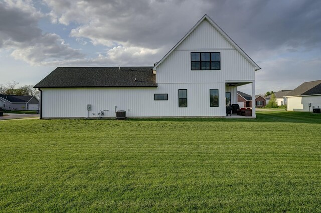 2737 Executive Dr, Troy, OH 45373 - rear view of house featuring a lawn, cooling unit, a patio, and a shingled roof
