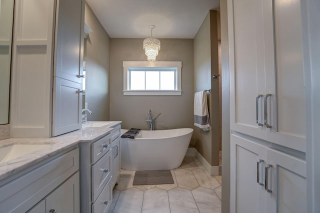 2737 Executive Dr, Troy, OH 45373 - full bath with a freestanding bath, double vanity, tile patterned flooring, a chandelier, and baseboards