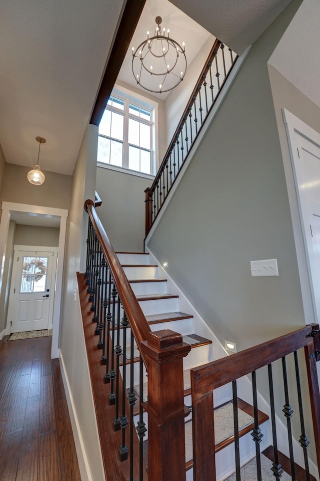 2737 Executive Dr, Troy, OH 45373 - staircase featuring baseboards, hardwood / wood-style floors, and a chandelier