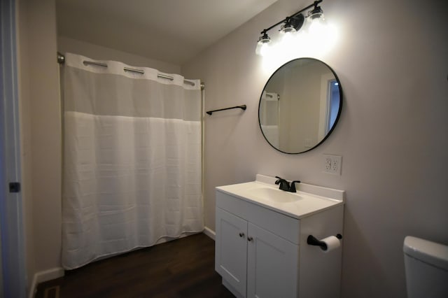 full bathroom with a shower with shower curtain, vanity, toilet, and wood finished floors