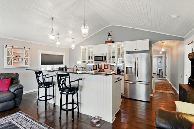 14506 Maple Ave, Lakeview, OH 43331 - kitchen with stainless steel appliances, arched walkways, dark countertops, vaulted ceiling, and dark wood-style floors