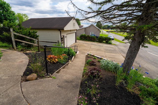 317 S Miami Ave, Xenia, OH 45385 - view of side of home featuring an outdoor structure, driveway, a shingled roof, and an attached garage