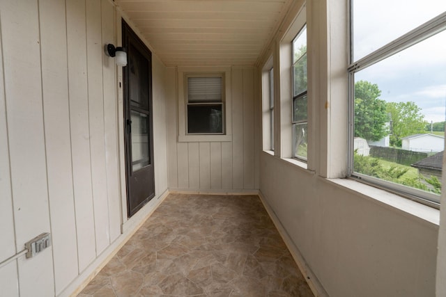 317 S Miami Ave, Xenia, OH 45385 - unfurnished sunroom featuring stone floors, healthy amount of natural light, and wood walls