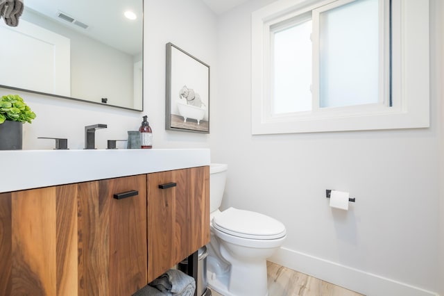 7925 Hickory Ave, Russells Point, OH 43348 - half bathroom featuring toilet, wood finished floors, vanity, and baseboards