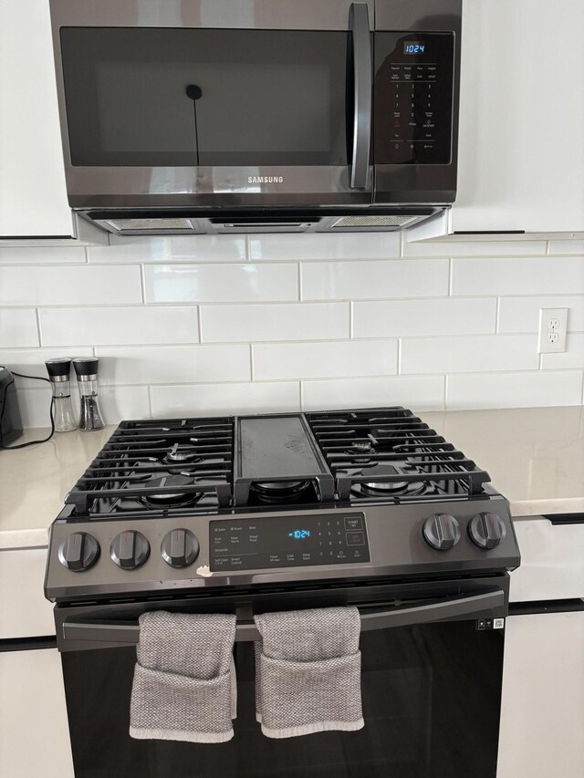 7925 Hickory Ave, Russells Point, OH 43348 - detailed view of appliances with stainless steel finishes, tasteful backsplash, and light countertops