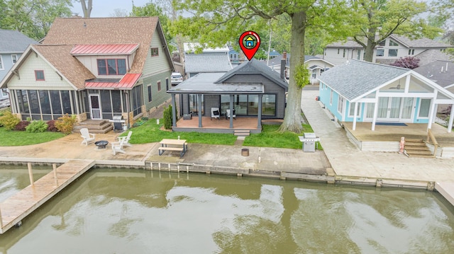 7925 Hickory Ave, Russells Point, OH 43348 - rear view of house featuring a sunroom, a deck with water view, a patio, and roof with shingles