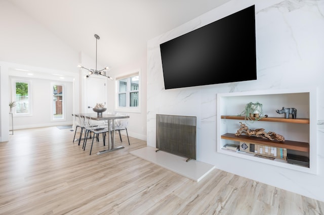 7925 Hickory Ave, Russells Point, OH 43348 - living area with wood finished floors, a chandelier, vaulted ceiling, and plenty of natural light