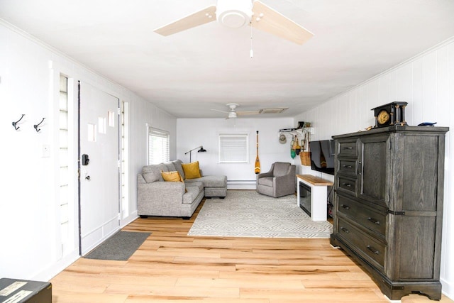 9887 Forest St, Lakeview, OH 43331 - living room with a ceiling fan, light wood-style floors, crown molding, and a baseboard radiator