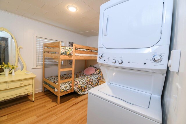 9887 Forest St, Lakeview, OH 43331 - laundry area featuring stacked washer and clothes dryer, light wood finished floors, and baseboards