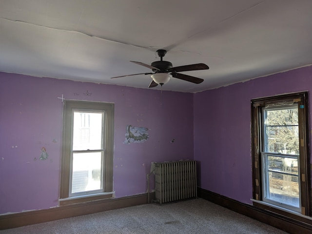 unfurnished room featuring ceiling fan, radiator heating unit, and carpet