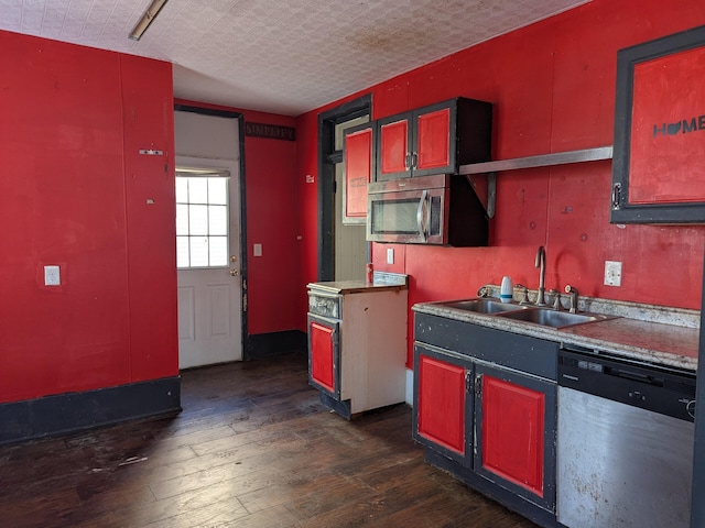 kitchen featuring appliances with stainless steel finishes, sink, a textured ceiling, and dark hardwood / wood-style flooring