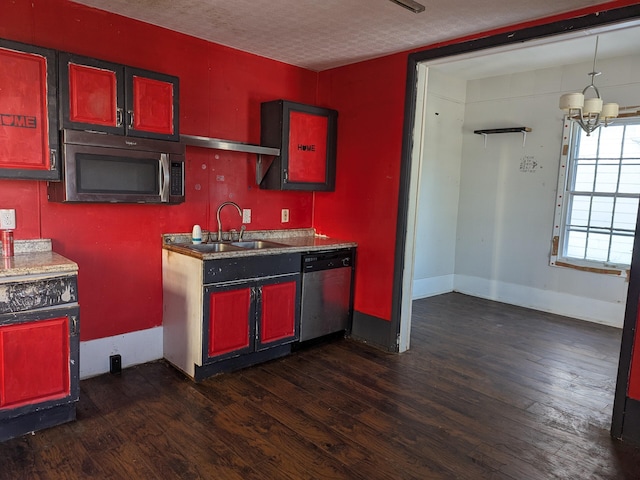 kitchen featuring dark wood-type flooring, stainless steel appliances, a chandelier, and a textured ceiling