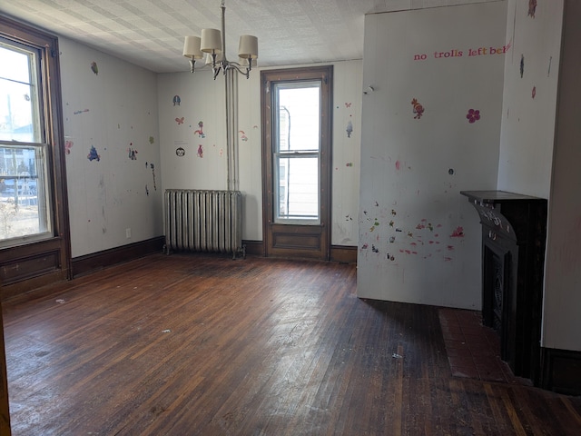 interior space with radiator heating unit, dark hardwood / wood-style floors, and a chandelier