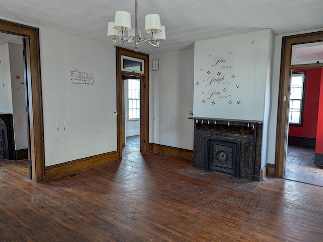 unfurnished living room featuring dark hardwood / wood-style floors and a chandelier