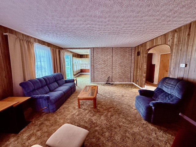 7188 Clark Dr, Russells Point, OH 43348 - carpeted living room featuring arched walkways, wooden walls, and a textured ceiling