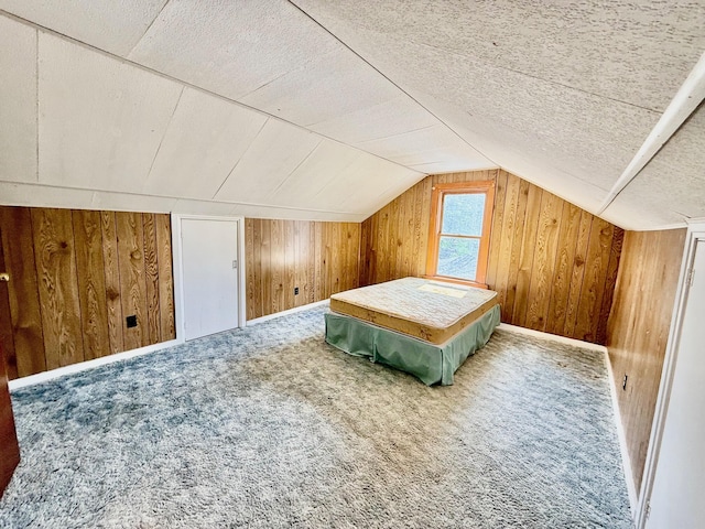 7188 Clark Dr, Russells Point, OH 43348 - bedroom with wooden walls, lofted ceiling, carpet flooring, and a textured ceiling
