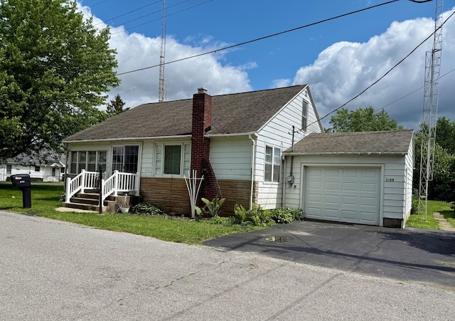 7188 Clark Dr, Russells Point, OH 43348 - view of front of property featuring asphalt driveway, a chimney, a shingled roof, and a garage