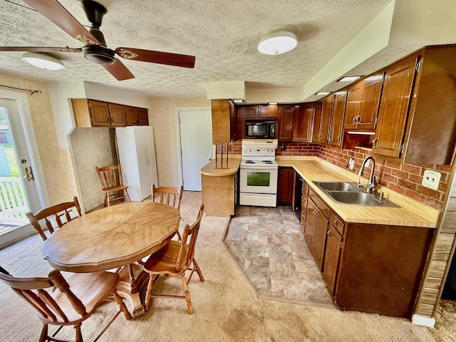 7188 Clark Dr, Russells Point, OH 43348 - kitchen with black appliances, light countertops, light colored carpet, a textured ceiling, and backsplash