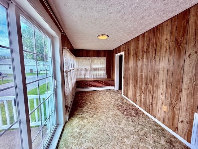 7188 Clark Dr, Russells Point, OH 43348 - hallway with a textured ceiling, wooden walls, carpet floors, and a baseboard heating unit