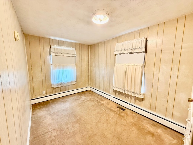7188 Clark Dr, Russells Point, OH 43348 - carpeted empty room with wood walls and a baseboard radiator