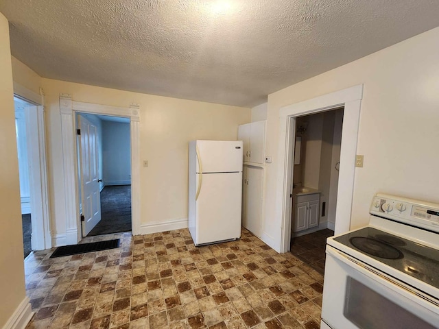 127 N Sycamore St, Union City, OH 45390 - kitchen featuring white appliances, baseboards, a textured ceiling, and dark stone finish flooring